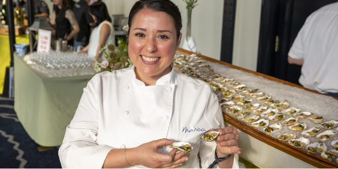 A chef smiling and posing at a previous year’s Chefs’ Tribute to Citymeals on Wheels in New York City