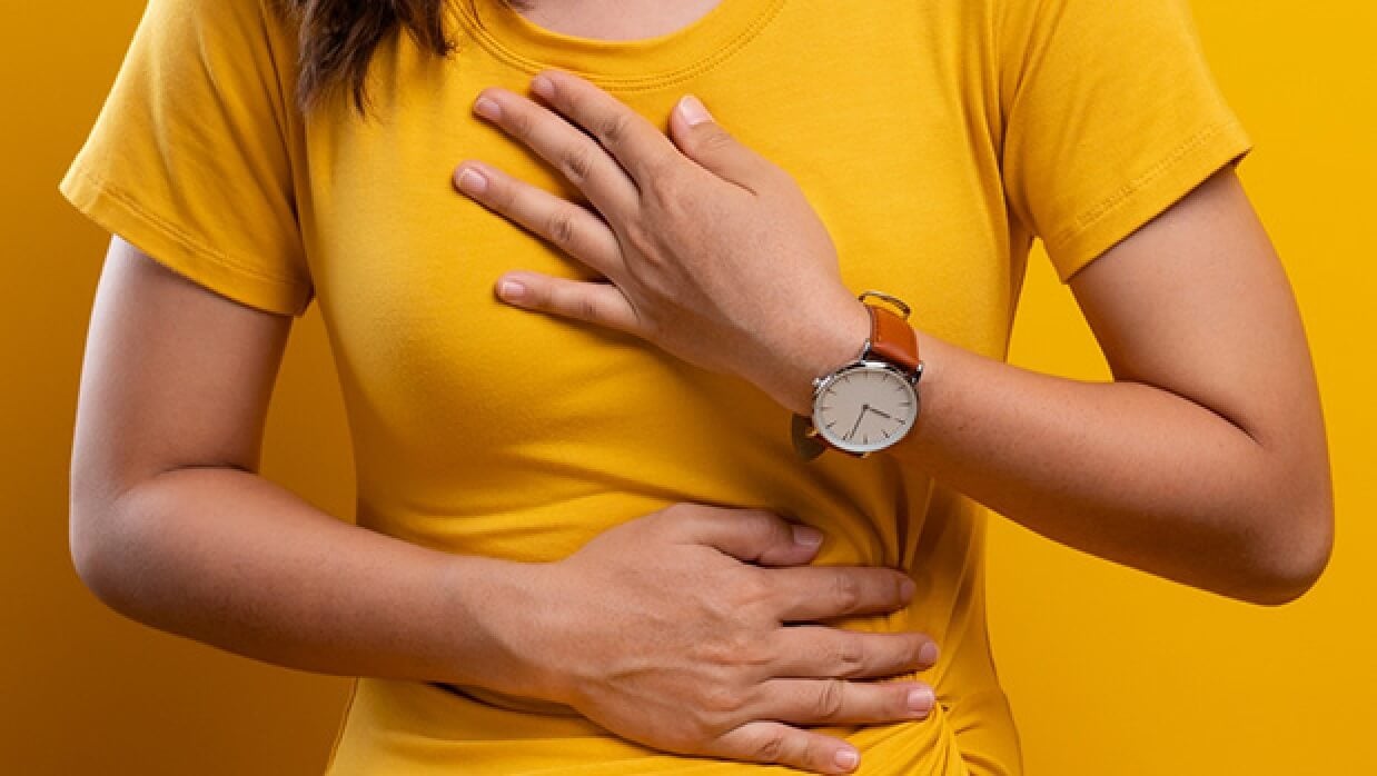 Woman with heartburn clutching chest